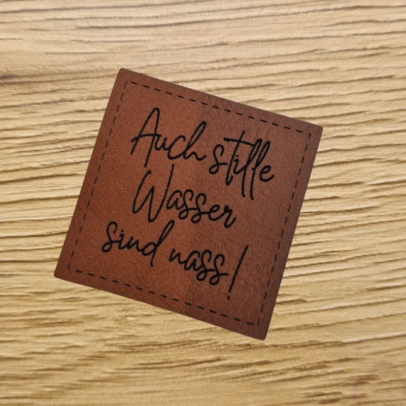 „Auch stille Wasser sind nass“ Nählabel 4×4 cm – vegan, handmade, Schnuckidu® Kunstleder Braun/Schwarz Expressversand