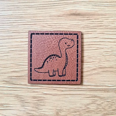 „Baby Dino“ Nählabel 4×4 cm – vegan, handmade, Schnuckidu® Kunstleder Braun/Schwarz Preiswert